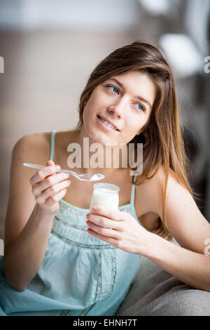 Donna di mangiare yogurt. Foto Stock