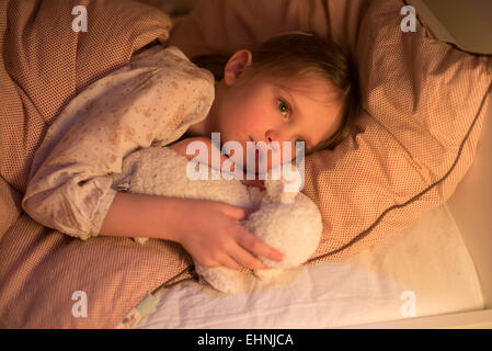 5 anno-vecchia ragazza sdraiato sul letto. Foto Stock