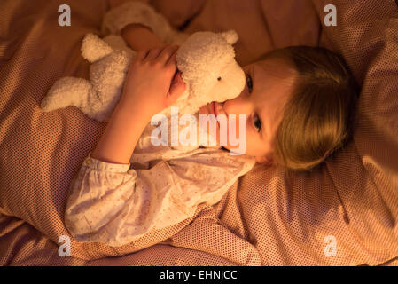 5 anno-vecchia ragazza sdraiato sul letto. Foto Stock