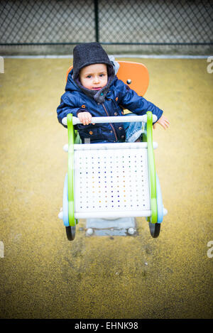 18 mese-vecchio baby boy in un parco giochi. Foto Stock