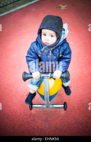 18 mese-vecchio baby boy in un parco giochi. Foto Stock