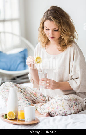 Donna di bere spremuta di succo di limone. Foto Stock