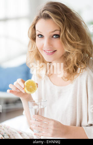 Donna di bere spremuta di succo di limone. Foto Stock