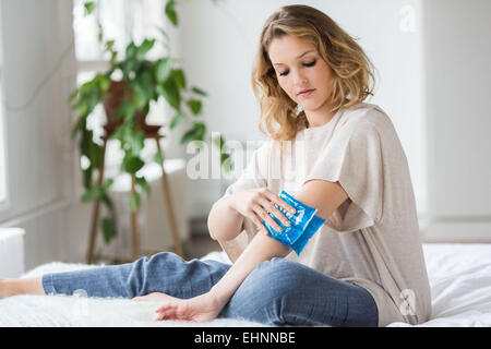 Donna che utilizza un caldo-freddo pacco gel per il trattamento del dolore releive. Foto Stock