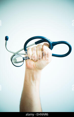 Mano che tiene uno stetoscopio. Immagine concettuale su la sfida dei medici. Foto Stock