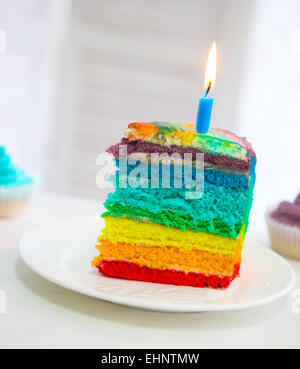 Rainbow torta decorata con candela di compleanno sul tavolo di compleanno Foto Stock