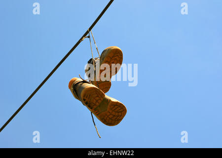 Scarpe appeso su una linea di potenza Foto Stock