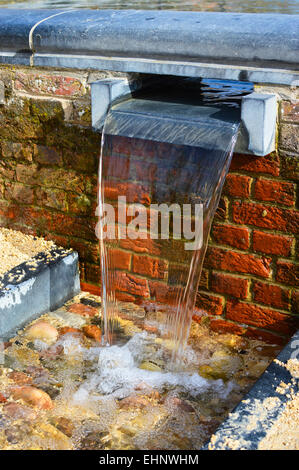 L'acqua che scorre dalla piscina nel giardino ornamentale in Alnwick giardino, Northumberland Foto Stock