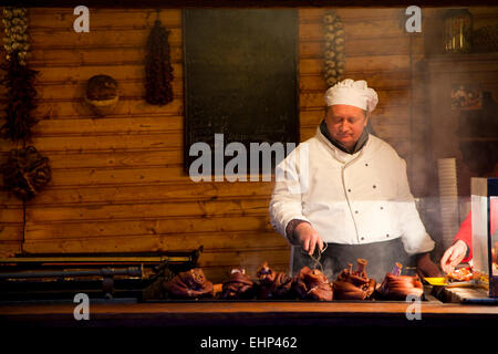 Un chef carne su un grill in un mercatino di Natale di Budapest, Ungheria Foto Stock