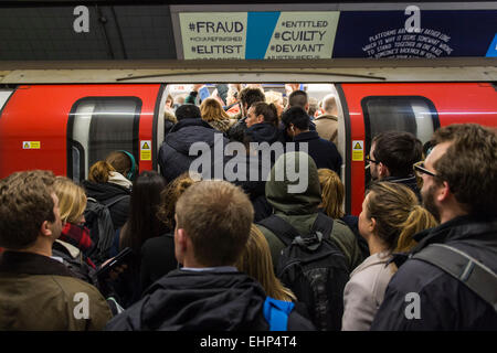 Londra, Regno Unito. 16 marzo, 2015. I passeggeri attendono pranzo Northern Line treni a Stockwell station. Essi sono bombardati da annunci che tutte le linee che hanno un buon servizio e si trovano di fronte ad un utile segno, condizionati da TFL, dicendo loro di non si affollano attorno a una porta. Purtroppo sono costretto dal peso di numeri per stand pericolosamente vicino al bordo della piattaforma. Stockwell Station sulla linea del Nord, Londra Unerground, 16 Mar 2015. Credito: Guy Bell/Alamy Live News Foto Stock