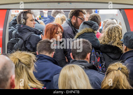 Londra, Regno Unito. 16 marzo, 2015. I passeggeri attendono pranzo Northern Line treni a Stockwell station. Essi sono bombardati da annunci che tutte le linee che hanno un buon servizio e si trovano di fronte ad un utile segno, condizionati da TFL, dicendo loro di non si affollano attorno a una porta. Purtroppo sono costretto dal peso di numeri per stand pericolosamente vicino al bordo della piattaforma. Stockwell Station sulla linea del Nord, Londra Unerground, 16 Mar 2015. Credito: Guy Bell/Alamy Live News Foto Stock