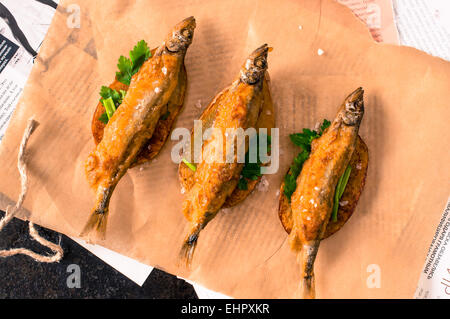Pesce e patatine fritte, pesce in pastella in fettine di patate fritte su carta e giornale Foto Stock