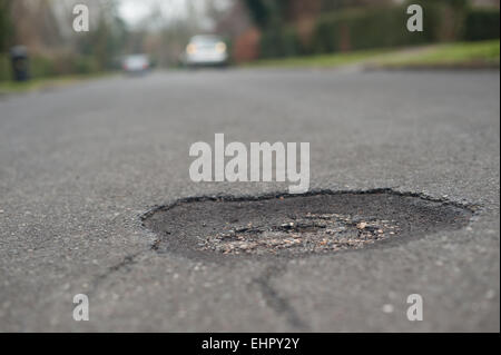 Nella necessità di riparare una buca appare nel mezzo di un asfaltato superficie stradale la creazione di un foro di buttare i ciclisti incidenti off Foto Stock