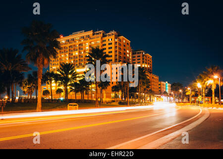 Lo spostamento del traffico passato un hotel e palme su Coronado guidare di notte, in Clearwater Beach, Florida. Foto Stock