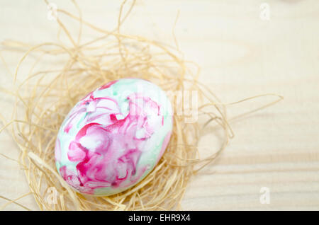 Dipinto a mano uovo di Pasqua e le cannucce su un tavolo Foto Stock