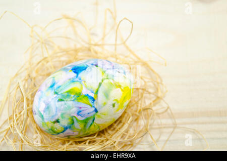 Dipinto a mano uovo di Pasqua e le cannucce su un tavolo Foto Stock