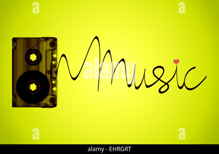 Una cassetta a nastro su un verde lime retro-illuminato lo sfondo con del nastro in uscita della cassetta per scrivere la parola musica. Foto Stock