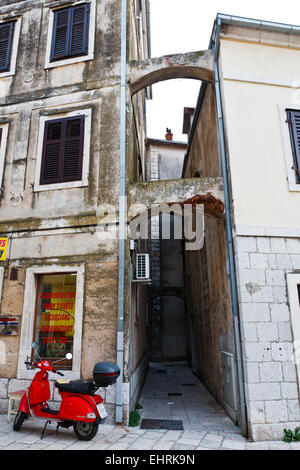 Ciclomotore rossa parcheggiata vicino a Archway in Omis, Croazia Foto Stock