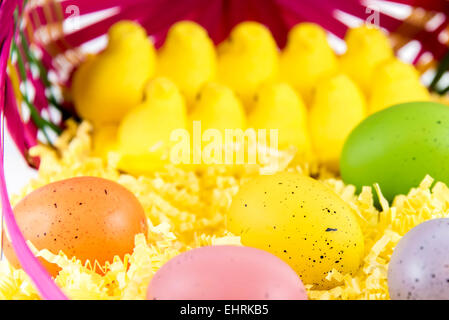 Colorate le uova di Pasqua, giallo di pulcini e la caramella in un cestello Foto Stock