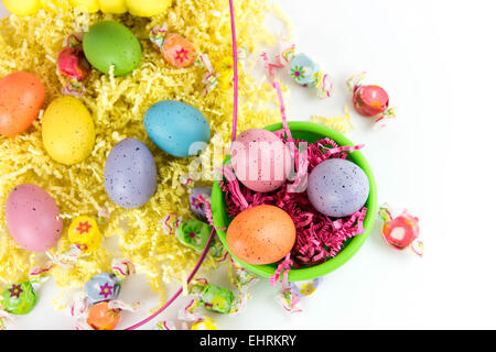 Colorate le uova di Pasqua, giallo di pulcini e la caramella in un cestello Foto Stock