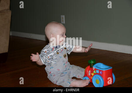 Il bambino gioca con il suo toy train. Foto Stock