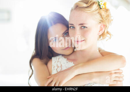 Ritratto di damigella abbracciando sposa in camera da letto Foto Stock