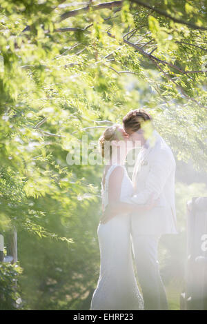 Coppia giovane kissing nel giardino interno Foto Stock