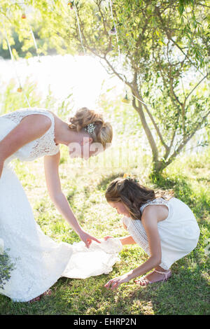 Sposa e damigella nel giardino interno durante il ricevimento di nozze Foto Stock