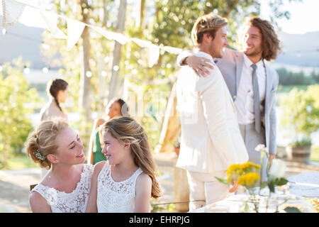 Sposa parlando di damigella durante il ricevimento di nozze nel giardino interno Foto Stock