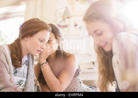 Tre ragazze adolescenti spettegolare in camera Foto Stock