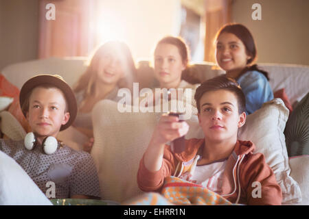 Un gruppo di adolescenti di guardare la TV sul divano insieme Foto Stock