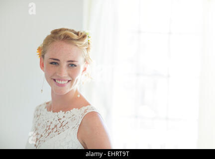 Ritratto di sposa sorridente in stanza soleggiata Foto Stock