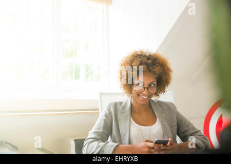 Ritratto di sorridere lavoratore di ufficio con smart phone Foto Stock