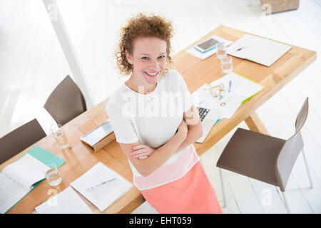 Ritratto di donna con le braccia incrociate,sorridente in ufficio Foto Stock