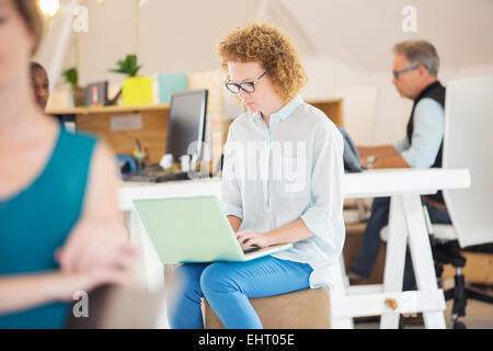 Donna e uomo seduto e lavoro in ufficio Foto Stock