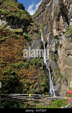 Il Bhutan - bandiere di preghiera da una cascata in prossimità di ingresso al Taktshang Goemba, (Tiger's Nest monastero), arroccato sul fianco di una scogliera. Foto Stock