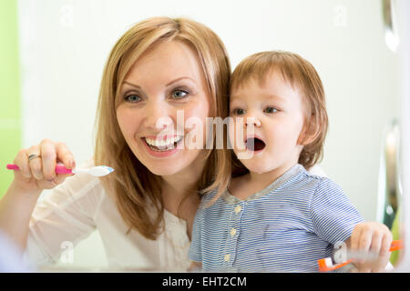 La madre del bambino di insegnamento di spazzolamento dei denti Foto Stock