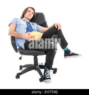 Lazy uomo seduto in poltrona con una ciotola di pop corn isolato su bianco Foto Stock