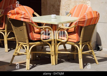 Sedie di vimini e tavolo in una street cafe Foto Stock