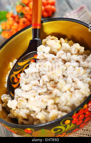 Orzo perlato porridge nel recipiente. Foto Stock