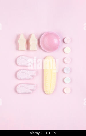 Caramelle prevista e organizzata su un sfondo rosa Foto Stock