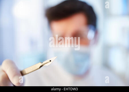 Focus sulla mano d'uomo tenendo un bisturi Foto Stock