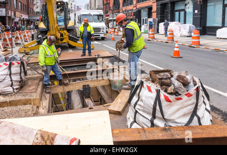 Lavoratori la rimozione di detriti da rottura di un tratto della metropolitana di New York City di infrastruttura su Grand Street in Little Italy Foto Stock