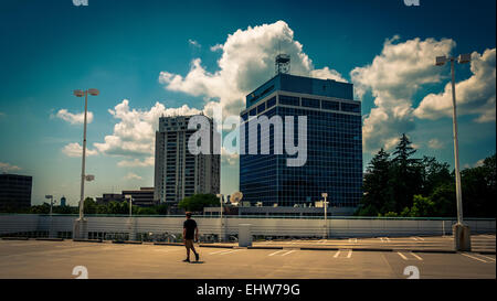 Vista di highrises e un uomo che cammina su un garage per il parcheggio in Towson, Maryland. Foto Stock