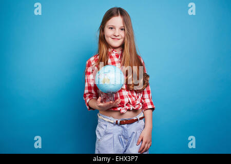 Ragazza intelligente mantenendo un piccolo globo Foto Stock