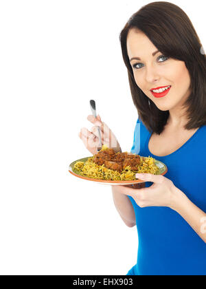 Attraente giovane donna mangiando carne di agnello rogan josh curry indiano Foto Stock