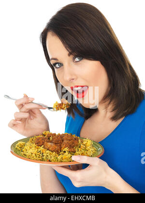 Attraente giovane donna mangiando carne di agnello rogan josh curry indiano Foto Stock