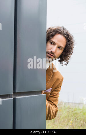 Curioso uomo nascondere cercando snoopy sospetto Foto Stock