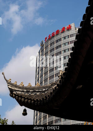 Dettaglio del tetto ornato del Tempio del Buddha di Giada accanto a un edificio moderno a Shanghai in Cina Foto Stock