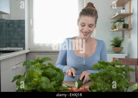 Ritratto di donna attraente cucina insalata di preparazione Foto Stock